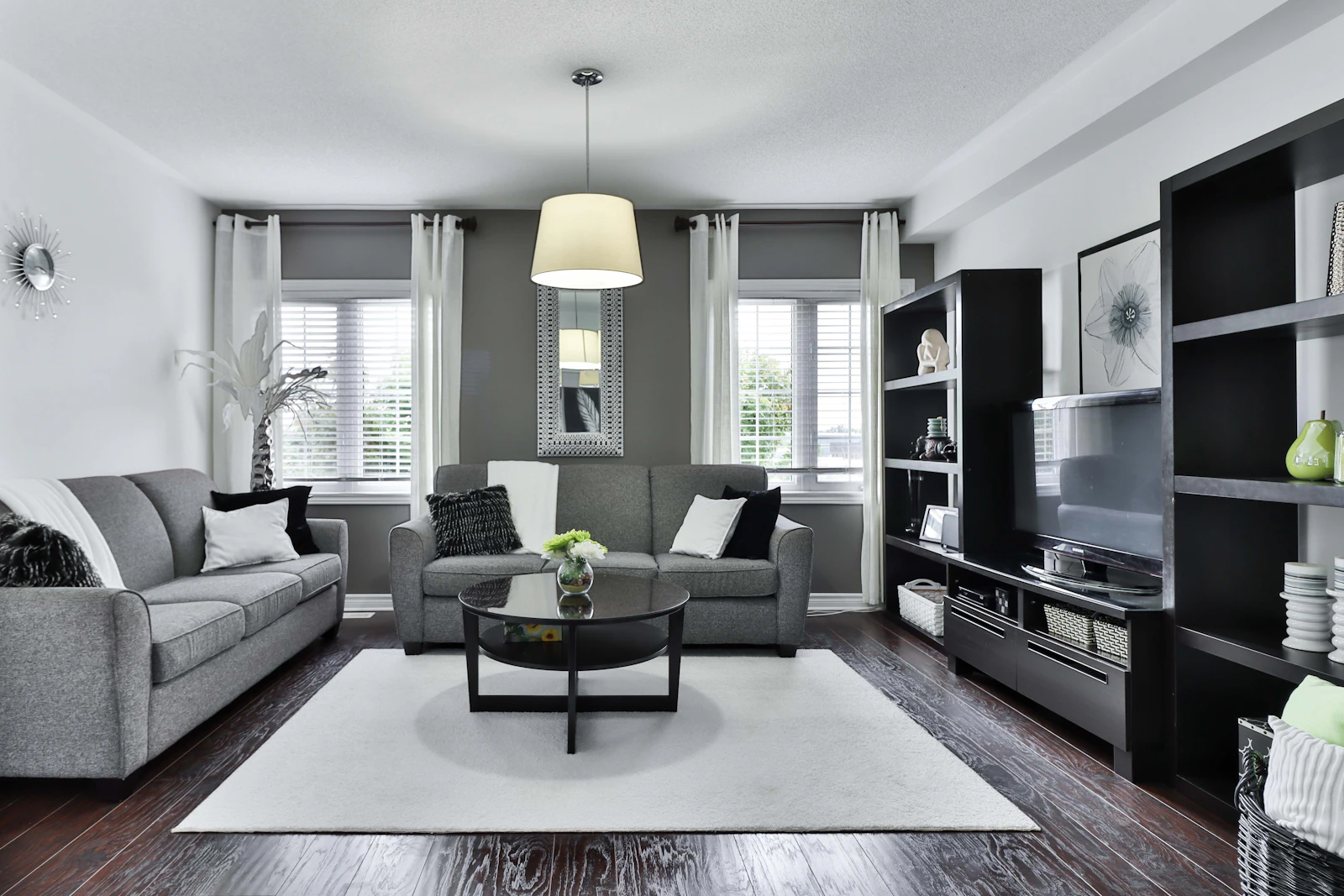 Living room with two gray sofas facing a coffee table, a media wall, and a central rug, shown as a furniture grouping example.
